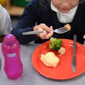 Stock picture of a child eating a school meal