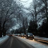 Cars drive on snowy roads in Liverpool.