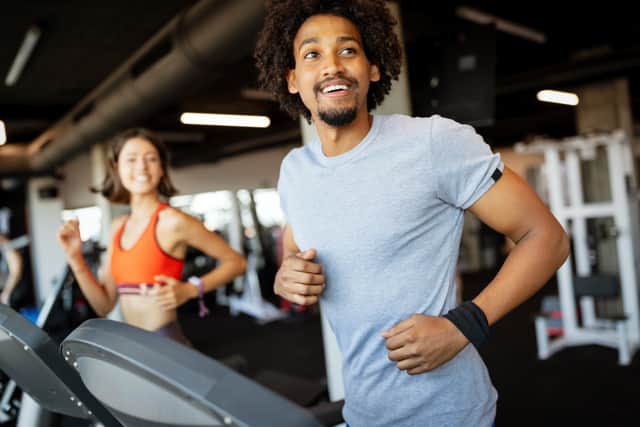 Friends exercising on a treadmill in gym (Adobe Stock)