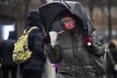 Woman walks in stormy conditions.