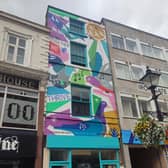 Multi-coloured painted pigeons emblazoned on the old Foulds music shop, soar above the city, keeping a watchful eye on Derby residents