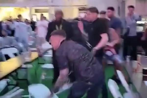 Men can be seen throwing chairs across the room at the Winter Gardens first Euros Fanzone match. 