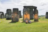 Activists sitting by Stonehenge after it was sprayed orange (Photo: Just Stop Oil / Supplied)
