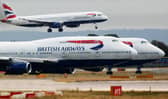 A British Airways plane lands as two other grounded planes sit on the runway at Heathrow Airport.