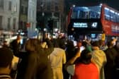 Excited England fans dance around “Bellingham” bus.
