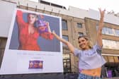 Ashley puts sweat shame to sweat fame by standing in front of her sweating billboard as the new face of Extra Flamin' Hot snacks