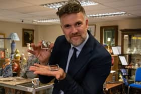 Lord Nelson's buckles will go under the hammer on November 28, 2024. Pictured is auctioneer Charles Hanson holding the buckles