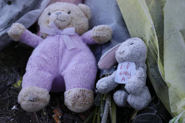 Flowers and stuffed toys are left as tributes to 'Baby A'.