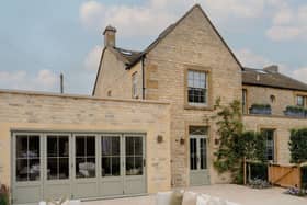 The exterior is a classic Cotswolds house, made from the local stone