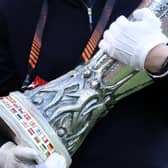 A UEFA official carrying the Europa Cup Trophy 