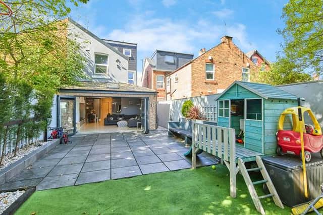 The rear garden provides a practical outdoor space with patio seating, lawn and a useful brick-built outbuilding for storage or hobbies