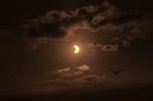 Birds fly past a partial solar eclipse, seen over Liverpool Bay from Crosby Beach on 12 August 2026 in Liverpool, United Kingdom.