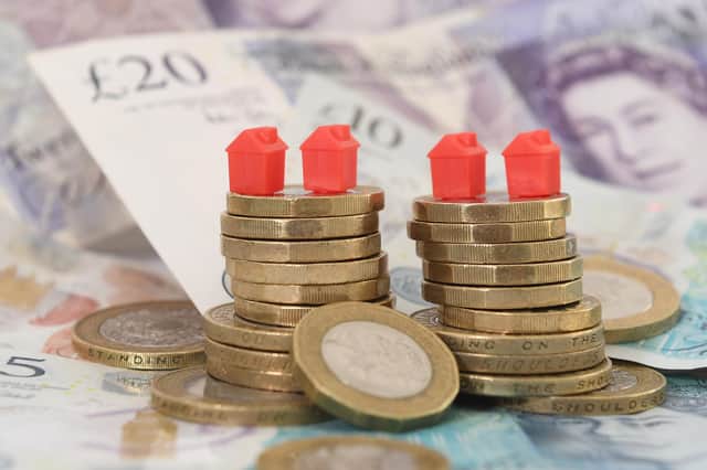 EMBARGOED TO 0001 TUESDAY FEBRUARY 28 File photo dated 12/09/18 of model houses on a pile of coins and bank notes, as House sellers are shaving just over £14,000 off their original asking prices typically to achieve a sale, according to a property website. Zoopla analysed agreed sales, looking at the differences between original asking prices and eventual selling prices. Sales where discounts had not been made were also included. Issue date: Tuesday February 28, 2023.