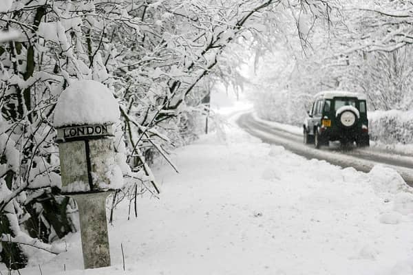 A car drives past a snow-covered mile-marker sign in Derbyshire on March 23, 2013. Heavy unseasonal snowfall hit, bringing sub-zero temperatures and travel disruption across the area.