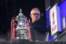 Gary Lineker sits in the BBC Studio next to the FA Cup