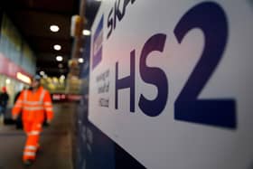 A worker walks past a sign outside a construction site for HS2 at London Euston station