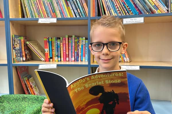Logan Sparrow with the book he self-published