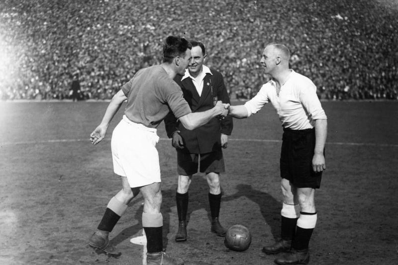 Manchester City and Derby County captains Cowan and Cooper shake hands in front of referee J W Lucas, beforerthe kick off of an FA_Cup semi-final at Huddersfield Town's ground on 19th March 1933. Man City would 3-2.