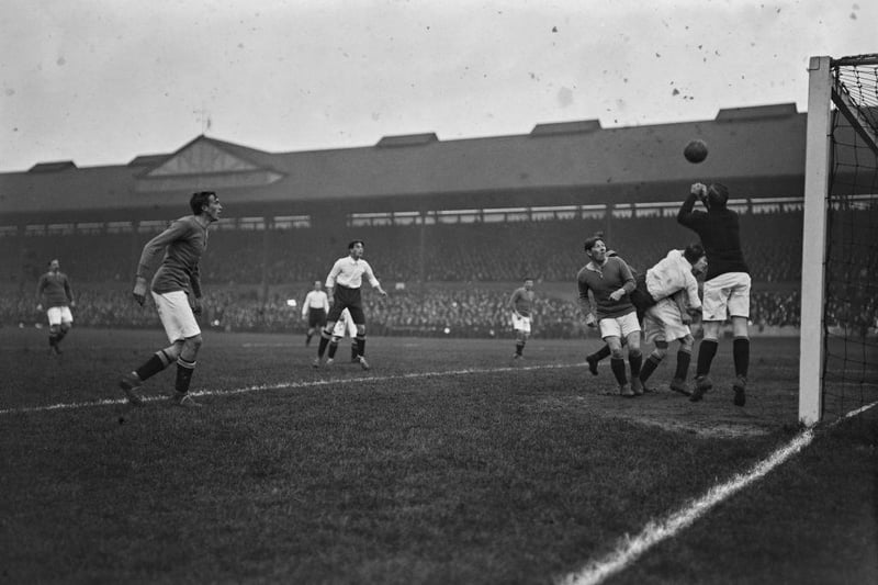 Chelsea goalkeeper Jim Molyneux punches away the ball during a match against Derby County at Stamford Bridge on November 15th 1913. Second from left is Danish half back Nils Middleboe, who is making his Chelsea debut. Chelsea defeated Derby 2-1.